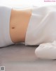 A woman laying on the ground with her stomach exposed.