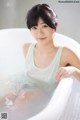 A woman sitting in a bathtub with water in it.